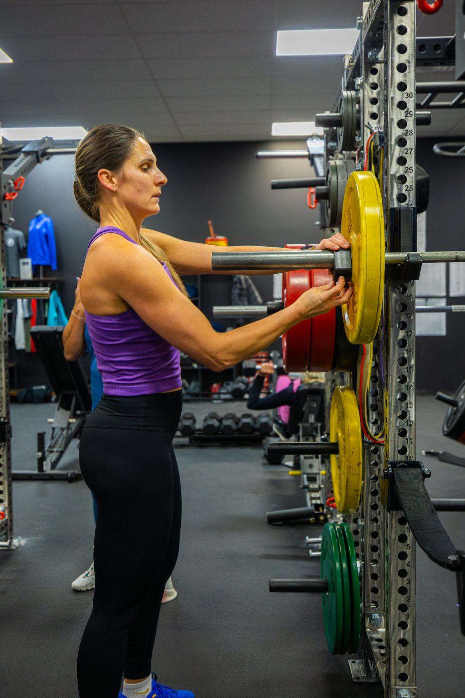 Loading plates during a strength session at Gas House Gym
